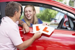 Photo of girl with L plates on driving lesson